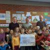 Die Gesamtschule Wiesentheid freut sich über eine 1000-Euro-Spende. Im Bild Markus Leckert und Florian Rückel (KTU-Spedition), Carsten Busch (Schule) und die Schüler der Klasse 2a bei der symbolischen Scheckübergabe.