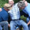 Nach alter Tradition wird der neue Feldgeschworene auf einem Grenzstein gestaucht damit er die Grenze nie vergessen mag (von links): Michael Herold, Jürgen Hetzer und Matthias Wolf.