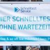 Vor einem Testzentrum an einem Transparent mit der Aufschrift "Hier Schnelltest - Ohne Wartezeit". Restaurants, Hotels und der Einzelhandel dürfen wieder aufmachen - Besucher müssen geimpft oder genesen sein oder einen negativen Test vorlegen. 