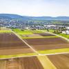 Das Bergamt Nordbayern hat das Genehmigungsverfahren zur Erweiterung des Quarzsand-Tagebaus "Nordöstlich Sand am Main" Ende April eingestellt. Das Bild zeigt Sand am Main von oben mit Agrarflächen, aufgenommen aus Richtung Zeil, rechts ist der Sander Baggersee zu sehen.