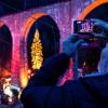 Ein Besucher fotografiert in Breitnau (Baden -Württemberg) mit seinem Handy den Weihnachtsmarkt unter dem Aquädukt in der Ravennaschlucht. Ein Besucher fotografiert in Breitnau (Baden -Württemberg) mit seinem Handy den Weihnachtsmarkt unter dem Aquädukt in der Ravennaschlucht.