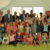 Nehmen ihre beliebte Leiterin gerne in die Mitte: Gabi Halbig (mit Blumen) ist seit 40 Jahren Leiterin des Heustreuer Kindergartens, der heutigen Kindertagesstätte "Mittendrin" in Heustreu.