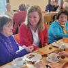 Pflegemitarbeiterin Jolana im Gespräch mit zwei Gästen beim Herbstfest der Caritas-Sozialstation St. Klara.