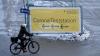 Eine Frau fährt in München mit ihrem Fahrrad an einem Plakat mit der Aufschrift "Corona Teststation" entlang (Symbolfoto).