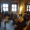 Im Vordergrund ist Prof. em. Norbert Klaes zu sehen, neben ihm Ahmet Bastürk als Vertreter der Würzburger Muslime. Am Fenster sind die Hauptaktuere aufgereiht, von links: Imam Zahir Durakovic von den bosnischen Muslimen, Hamza Özkan vom Verein Selam Mainfranken, hinter ihm Aleksander Shif von der Jüdischen Gemeinde, rechts daneben Pfarrerin Susanne Wildfeuer, am zweiten Fenster Edith Battel vom sozialen Buddhismus. Andere Akteure sind nicht zu sehen.