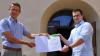 Oberbürgermeister Sebastian Remelé übergibt Julius Leimeister, Junior Geschäftsführer der Rudolf Leimeister Wäscherei GmbH & Co. KG, die Teilnahmeurkunde am Umwelt- und Klimapakt Bayern.