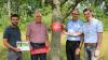 Ein Winterhäuser Obstbaum für alle: (von links) Allianzmanager Bastian Lange sowie die Bürgermeister Hubert Henig aus Theilheim, Christian Luksch aus Winterhausen und Markus Schenk aus Eibelstadt bringen die Banderole an.