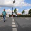 Gleichzeitig losgelaufen, aber unterschiedlich schnell: Während Quartiersmanager Sebastian Restetzki (links) mühelos bei Grün über die B 8 in der Kitzinger Siedlung läuft, schafft der Fußgänger mit Rollator (rechts) in derselben Zeit nur die halbe Strecke.