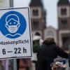 Schilder verweisen auf der Alten Mainbrücke in Würzburg auf die Maskenpflicht im Bereich der Brücke.