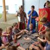 Ins antike Rom vor 2000 Jahren zurückversetzt wurden die Kinder im Rahmen der Ferienspaßaktion im Sportheim Herlheim. Im Bild einige Teilnehmer bei ihrer Arbeit am Handwerkertisch, dahinter Schüler in Legionärsausrüstung.