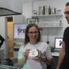 Vorstandsvorsitzende Melina Hüpschle zeigt eine gravierte Brotzeitdose mit Wirtschaftspaten Adrian Dümpert (rechts).
