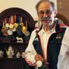 Sportschütze Roland Hartmann zeigt stolz einiger seiner wichtigsten Medaillen, die er in seiner über 30-jährigen Karriere gesammelt hat.