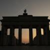 17.02.2019, Berlin: Nur als Silhouette ist das Brandenburger Tor im Gegenlicht der aufgehenden Sonne zu sehen, während ein Flugzeug über das Berliner Wahrzeichen fliegt. Foto: Paul Zinken/dpa +++ dpa-Bildfunk +++ | Verwendung weltweit 17.02.2019, Berlin: Nur als Silhouette ist das Brandenburger Tor im Gegenlicht der aufgehenden Sonne zu sehen, während ein Flugzeug über das Berliner Wahrzeichen fliegt. Foto: Paul Zinken/dpa +++ dpa-Bildfunk +++ | Verwendung weltweit