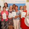 Die Preisträgerinnen des „Weißen Engels“ (von links): Gabriele Reusch, Kunigunda Dirauf, Luzia Löfflad, Rosemarie Knechtel, Gertrud Bausewein, Brigitte Gehlofen, Brigitte Klee, Hildegard Roth und Ella Ludwig mit Melanie Huml, Staatsministerin für Gesundheit und Pflege. Nicht auf dem Bild: der Preisträger Hartmut Schmitt.