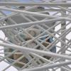 Wie im Spinnennetz: eine Gondel hinter Stäben und Verankerungen. Wie im Spinnennetz: eine Gondel hinter Stäben und Verankerungen.