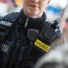 Eine Polizistin der Bundespolizei trägt eine mobile Kamera.