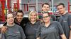 Inklusion bei Würth Industrie Service: Mitarbeiter mit und ohne Handicap vor der neuen Packstraße im Werk in Bad Mergentheim, an der sie gemeinsam arbeiten.