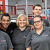 Inklusion bei Würth Industrie Service: Mitarbeiter mit und ohne Handicap vor der neuen Packstraße im Werk in Bad Mergentheim, an der sie gemeinsam arbeiten.