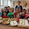 Stolzen präsentieren die Zweitklässler der Sinngrundschule die selbst zubereiteten, gesunden Speisen.
