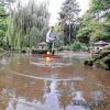 Großreinemachen mit dem Besen: Aus dem Teich im Klein-Nizza wurde jetzt das Wasser abgelassen, die Anlage ist undicht und muss grundlegend saniert werden. Gartenamtsmitarbeiter André Preißinger schob den Schlamm zusammen.