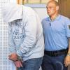 Angeklagt wegen Mordversuchs: Der 40-jährige Mann aus Uffenheim, der hier mit einem Justizbeamten den Gerichtssaal betritt und dabei sein Gesicht verbirgt, soll der Brandstifter von Harthausen sein.