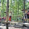 (rsf)   „O, ist der Gurt schwer“, „O, ist der Gurt schwer“, diese Sätze sind von den Kindern zu hören, als sie im Kletterwald am Ellertshäuser See die Sicherheitsgurte anlegen. Die Fünf- bis Neunjährigen waren an diesem Vormittag in das etwa 4000 Quadratmeter Areal der Eventagentur im Rahmen des Stadtlauringer Ferienprogramms zu abwechslungsreichen und spannenden Seilübungen eingeladen. Start war mit dem Anlegen des Gurtes, danach wies Armin Dietz, der Chef des Klettergartens am See, die Kinder im Umgang mit den Karabinerhaken beim Klettern mit Seil ein. „Immer nur einen Karabiner umhängen“, schärfte er ihnen ein. Dies übten die Kids zunächst beim Gehen am Seil auf dem Waldboden. Als Betreuer standen ihnen bei den Kletterübungen Jeannette Hub und Anna Göpfert, die beide schon zum Klettern hier waren, mit Rat und Tat zur Seite. Nach dem Erlernen der Grundkenntnisse konnten die Kinder diese auf dem Kinderseilparcours anwenden und hatten jede Menge Spaß dabei.