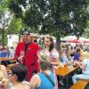 (bert)   Während viele Feste am Wochenende unter der brütenden Hitze litten, hatten es die Besucher in Obereisenheim viel angenehme – obwohl das Weinfest dort „Höllische Pfingsten“ heißt, benannt nach der bekannten Weinlage Obereisenheimer Höll. Das Fest unter grünen Bäumen auf einer Wiese direkt am Main, wo man auch baden kann, lockt inzwischen Besucher aus ganz Deutschland an. Mit dazu beigetragen hat ein großer Stellplatz für Wohnmobile, der am Wochenende wieder gut besucht war. Natürlich darf da auch die Obereisenheimer Weinprinzessin Christina Drescher nicht fehlen, deren Mutter Andrea Wägerle einmal Fränkische Weinkönigin war. Gemeinsam mit der Symbolfigur des Ortes, dem Teufel Heribert Prust, zog sie von Tisch zu Tisch und plauderte mit den Gästen (im Bild). Das Pfingstweinfest hatte früher der Winzerverein gemeinsam mit den Sportverein veranstaltet, dann ist es eingeschlafen. Aus dem Dornröschenschlaf geweckt haben es die beiden Obereisenheimer Winzer Günter Riegler und Klaus Jung. Sie sorgen mit einer Auswahl von Weinen für den ansprechenden Rahmen, und auch bei den Speisen gibt es eine viel Auswahl mit Braten, Steckerfisch oder auch einmal gefüllten Pirogi. Auch Kinder haben dort ihren Spaß, und von einem alten Leiterwagen spielt die Musik.