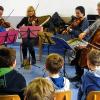 (rt)   Beim Projekt „Ohren auf“ des Würzburger Stadttheaters kommen Musiker des Philharmonischen Orchesters in Schulen und stellen ihre Instrumente und den Beruf des Orchestermusikers vor. Alexander Zeyher, Friederike Sturm-Haasis (beide Violine), Makoto Sudo (Viola) und Matthias Steinkrauß (Violoncello) besuchten die 3. und 4. Klassen der Grundschule Hellmitzheimer Bucht in Markt Einersheim. Das Streichquartett beeindruckte eine Stunde lang mit Werken aus unterschiedlichen Epochen. Darunter waren auch Mozarts „Kleine Nachtmusik“ und ein Ausschnitt aus dem „Kaiserquartett“ von Joseph Haydn, teilt Schulleiter Klaus Hana mit. Die Kinder hörten, dass ein Streichinstrument ganz verschiedene Klänge hervorbringen kann.  So ahmten die Musiker in Dvoraks „Amerikanischem Quartett“ eine Lokomotive nach, während bei einem anderen Stück Tierlaute zu erraten waren. Cellist Matthias Steinkrauß informierte über Bau- und Spielweise der Streichinstrumente.