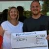 Sabrina Schäfer und Simon Herrmann präsentieren den symbolischen Scheck über 500 Euro an die Deutsche AIDS-Stiftung.