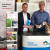 VGMT-Geschäftsführer Thorsten Haas (links) und der neue Mitarbeiter Jürgen Goldschmitt an einem Infostand: Die Verkehrsgesellschaft hat personelle Verstärkung für Informationsveranstaltungen und Mobilitätstrainings erhalten.