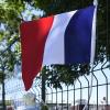 Eine französische Flagge und Blumen am Zaun der Firma Air Products nahe Lyon. Hier führte der 35-jährige Yassin S. seinen Anschlag aus.
