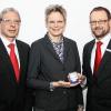 (ode)   Auf das Jahr 1276 geht die erste urkundliche Erwähnung Dettelbachs zurück. Das ist ein Grund zum Feiern und der Sparkasse eine Jubiläumsmedaille wert. Sie zeigt auf der Vorderseite das Faltertor und die Aufschrift „1275 Jahre Dettelbach, 741-2016“, die Rückseite ziert eine Stadtansicht mit Wappen und dem Aufdruck „Dettelbach am Main“. Die Münze ist in drei Ausprägungen erhältlich. Die Ausgabe in Feinsilber 999 gibt es in einer Auflage von 400 Stück und kostet 45 Euro. Daneben ist eine Goldprägung 585 in einer 20er Auflage erhältlich. Diese kostet nach derzeitigem Goldstand 555 Euro. Die Goldprägung 999, von der ebenfalls nur 20 Stück hergestellt werden, kostet gegenwärtig 749 Euro. Während die Silberausgabe vorrätig ist, müssen die Goldvarianten bestellt werden. Jede Medaille hat eine Prägenummer am Rand. Die Silbermünze mit der Nummer 1 erhielt Bürgermeisterin Christine Konrad von  Stefan Rohrmann (rechts), Geschäftsstellenleiter der Sparkasse Dettelbach und Volker Hertel (links), von der Herstellerfirma Noble House.