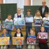 (hr)   An der Grundschule Hafenlohr fanden in diesem Schuljahr erstmals Experimentiertage statt. Das Ziel war, in den Kindern Neugier auf naturwissenschaftliches Arbeiten zu wecken und zu fördern, berichtet die Schule. Im Rahmen des HSU-Unterrichtes sollten die Kinder während eines Experimentiertages ein Naturphänomen anhand selbst aufgebauter Versuche entdecken und erklären können. Für die drei besten Forscher jeder Klasse hatte Harald Blum einen Preis ausgelobt. Klassenlehrkraft, Schulleiterin und Sponsor beobachteten die Kinder bei den Versuchen und ließen sich die Schlussfolgerungen der Buben und Mädchen aus den Experimenten erklären. Anhand wissenschaftlicher Kriterien wurden die drei talentiertesten Jungforscher ausgewählt. In der für alle gemeinsamen wöchentlichen Musikstunde wurden nun die besten Forscher, herausragende Sportler, der Büchereidienst und der Postdienst geehrt. Die stolzen Preisträger der Experimentiertage erhielten von Harald Blum einen Experimentierkasten. Zusätzlich stiftete Blum pro Klasse Einkaufsgutscheine für je zwei Kinder mit den besten schulischen Leistungen. Alle Schüler bedankten sich bei ihm mit der Schulhymne, dem HaBeRoWi-Lied. Das Foto zeigt die Preisträger des Experimentiertages mit Harald Blum.