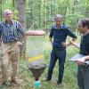 Uni-Kanzler Uwe Klug, Forstamtsleiter Hans Stark und Professor Jörg Müller (von links) lassen sich von Projektleiter Michael Junginger (rechts) die Funktionsweise einer Insektenfalle erklären. Diese soll später Erkenntnisse über die Artenvielfalt liefern.