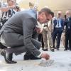 Rebstock-Chef Christoph Unckell beschriftet den frischen Beton, unter dem sich die Zeitkapsel für die Grundsteinlegung befindet.
