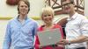 Erfolgreiche Jungunternehmer: Daniel Unger (links) und Axel Scheuering von der Firma Eology mit Landrätin Tamara Bischof und Laptop auf dem Volkacher Marktplatz.