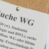 Studentinnen suchen mit Zetteln am Schwarzen Brett eine Wohnung. Studierende bezahlen nach einer aktuellen Erhebung immer mehr Miete.