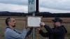 Das Schild an der Landesgrenze Bayern-Thüringen, an dem Marko Pabst (rechts) vor Monaten mit einem Mitstreiter ein Protestplakat gegen die geplante Sperrung der Straße von Gerthausen nach Weimarschmieden befestigt hat, war verschwunden. Nun hat sich der Verbleib geklärt: Der Fladunger Bauhof setzt es nach einem Parkrempler instand. Archivfoto: Pabst