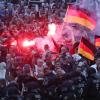 Demonstranten zünden in Chemnitz Pyrotechnik und schwenken Deutschlandfahnen. Foto: Jan Woitas