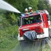 Übung: Im Fahren bekämpfen Volkacher Feuerwehrleute einen angenommenen Brand. Im Frontbereich ist der Löschbalken zu erkennen.