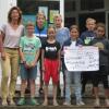 Rektorin Christine Tell übergibt den Spendenscheck über 800 Euro an Christian Öder vom Verein „Kinder unserer Welt“. Mit auf dem Bild sind einige fleißige Läufer der Schule. Foto: Grundschule Zell, Ulrike Debes