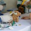  Mit ihren Puppen und Stofftieren besuchen Kinder die sogenannte "Teddy-Klinik" auf dem Gelände der Uni-Klinik. Marco (6) mit seinem Teddy Bruno, der sich das Bein aufgeschürft hat. Die beiden Doktoren behandeln den kleinen Patienten. Foto: Patty Varasano