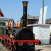 Bereits am Samstagmittag kündigte sich das Bahnjubiläum 150 Jahre Tauberbahn im Bahnhof Lauda an.  Um 11.27 Uhr fuhr die E-Lok 111 001-4 vom Eisenbahnmuseum Nürnberg mit einer besonderen Fracht im Bahnhof Lauda ein – auf Tiefgüterwagen der Nachbau des legendären Adlers von 1835 mit seinem Tender und zwei historischen Personenwagen.  Da auf Gleis 12 kein Strom ist, wurde der wertvolle Fracht mit dem Triebwagen VT 928 553 zur Abladeposition gebracht. Die Zaungäste und Fotografen brauchten jedoch viel Geduld bis das Spektakel schließlich kurz nach 13.30 Uhr begann.  Mit Manneskraft wurden zuerst die Planen entfernt, danach wurde gesichert und kurze Zeit später hing der Tender der Lokomotive am Haken – nach wenigen Minuten war dieser auf Gleis 12 aufgegleist.  Als nächster war der Adler dran – auch dieser hing nur wenige Minuten am Schwerlastkranen. Um 13.39 Uhr war der Adler gelandet. Die Eingleisung erfolgte mit viel Schwung und etwas Manneskraft.  Danach kamen die beiden Personenwagen dran. Um 14.15 Uhr trafen schließlich auch die anderen Diesel- und E-Lok-Raritäten im Bahnhof Lauda ein – alles in einer Zuggarnitur mit zahlreichen historischen Personenwagen – darunter auch der Rheingold – gezogen von der historischen E-Lokomotive E 40 128.