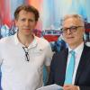 Zur Begrüßung überreicht Geschäftsführer Wilfried Neubauer (rechts) Dr. Olaf Anders einen Bildband über den Landkreis Haßberge.