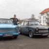Alexander Zierrath steht vor seiner Werkstatt in Randersacker zwischen zwei selbst restaurierten Trabis. Den grauen DDR-Kleinwagen hat der Fußball- und Unions-Fan mit dem Logo seines Lieblings-Fußballvereins verziert.