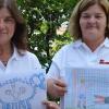 Trösten: Susann Lojewski (links) und Bettina Wohlleber mit Bildern von traumatisierten Kindern.