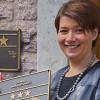 Aufgestiegen: Wirtin Katharina Rösser montiert das neue Schild am Deutschen Haus.