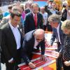 Mit allen Unterschriften: Verkehrsminister Winfried Hermann verewigt sich auf einem der auf die Zuglaufschilder „Tauberbischofsheim“, die künftig im Rathaus und dem Landratsamt hängen werden.