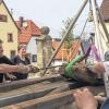 Aus dem dunklen Schacht ans Tageslicht befördert: Ein rund 250 Kilogramm schweres Steinfragment, vielleicht Teil einer Grabplatte. Vorne links Grabungsleiter Bernhard Häck mit der Brechstange bei der Bergung.FOTO: Sabine Wagner