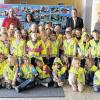 (kri)   Die 45 Mädchen und Jungen der beiden ersten Klassen der Grundschule begrüßten den Vorsitzenden des ADAC-Ortsclubs Ochsenfurt, Rechtsanwalt Stephan Wegner mit dem frisch erlernten Lied „Hurra, ich bin ein Schulkind“. Anschließend erhielten alle Kinder ihre eigene Sicherheitsweste, die sie gleich anprobieren durften. Alle 27 Minuten wird auf Deutschlands Straßen ein Kind von einem Auto erfasst, heißt es in einer Pressemitteilung des ADAC-Ortsclubs. Besonders gefährdet sind die Schulanfänger. Vor diesem Hintergrund verteilt der ADAC in einer bundesweiten Aktion zum Schulbeginn reflektierende Sicherheitswesten an die Erstklässler, mit denen ein Kind schon aus 150 m Entfernung erkannt werden kann. Im Bild die Klassen 1a und 1b und in der hinteren Reihe (von rechts) Schulleiterin Christina Held, Stephan Wegner vom ADAC-Ortsclub und die Klassenlehrer Andrea Mainka und Florian Hock, der die Kinder auf der Gitarre begleitete.